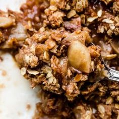 a close up of food on a plate with a spoon in it and some sort of granola