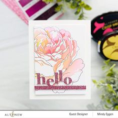 a close up of a card on a table with flowers and other items in the background