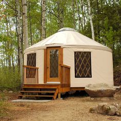 a yurt in the woods with steps leading up to it