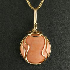 a gold pendant with an orange stone in the center on a black leather background photo