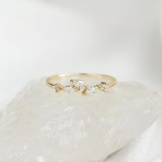 a gold ring with three diamonds on top of a rock