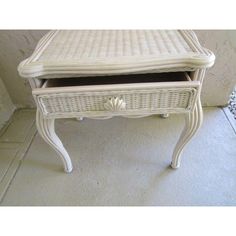 a white wicker desk with drawers on the bottom and one drawer at the top