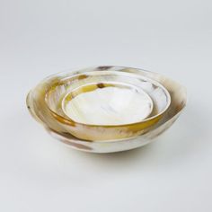 two white and brown bowls sitting side by side on top of each other in front of a white background