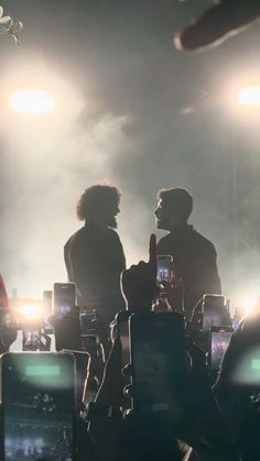 two people standing in front of some lights