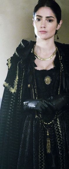 a woman dressed in black and gold with gloves