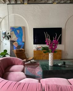 a living room filled with furniture and a large flat screen tv mounted to the wall