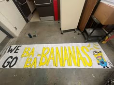 a banner that says we go ba - bananas on the floor next to some cabinets