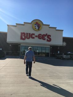 a man walking towards a buc - ee's store