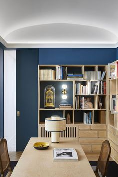 a dining room table with chairs and bookshelf in the backround area