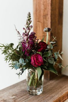 a vase filled with flowers sitting on top of a wooden table