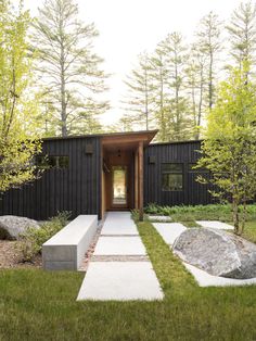 the entrance to a modern home in the woods