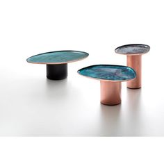 three tables with different designs on them, one is black and the other is copper