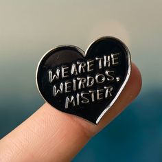 a heart shaped pin with the words we are the weirdos mister on it