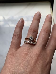 a woman's hand with two rings on it, and one is wearing a diamond ring