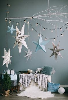 a room with stars hanging from the ceiling and decorations on the wall, including a bed