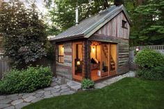 a small wooden shed with windows on the roof and doors open to let in light