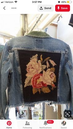 an old jean jacket with embroidered flowers on the back, hanging from a clothes hanger