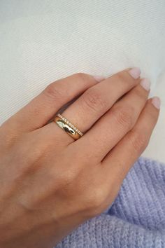 a woman's hand with a gold ring on it