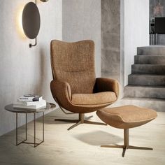 an egg chair and ottoman in front of a staircase with the jori logo on it