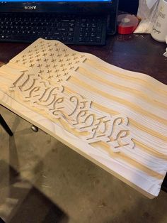 a wooden table with the word hope carved on it in front of a laptop computer