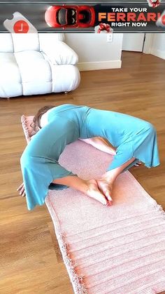 a woman in blue is doing yoga on a pink mat with her legs spread out