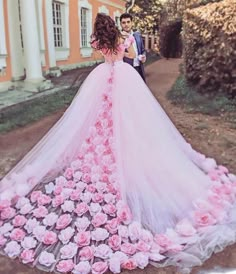 a woman in a pink dress standing next to a man