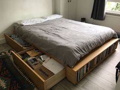 a bed with drawers underneath it in a bedroom