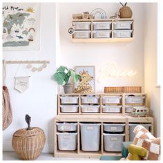 a room filled with lots of storage bins and baskets next to a wall mounted map