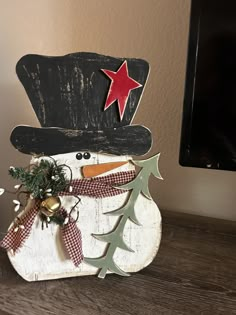 a wooden snowman with a top hat and bow tie on it's head