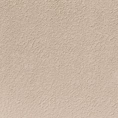 a beige stucco wall textured with white paint