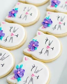 decorated cookies in the shape of cats with flowers on them