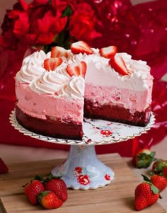 a strawberry cheesecake with one slice cut out on a cake plate next to strawberries