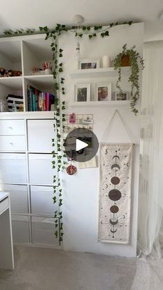 a room with white furniture and plants growing on the wall, along with bookshelves