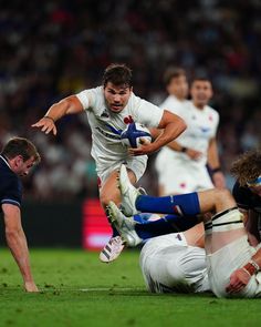 a rugby player running with the ball in his hand and other players behind him watching