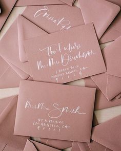 pink envelopes with calligraphy on them are laid out for the guests to use