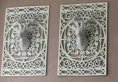 two white metal wall plaques with deer heads on them