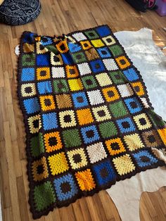 a crocheted blanket is laying on the floor