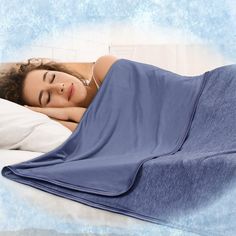 a woman laying in bed with her eyes closed and she is covered by a blue blanket