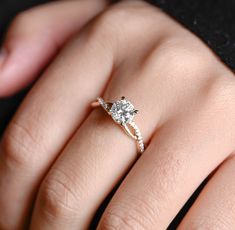 a woman's hand with a diamond ring on top of her finger and an engagement band