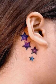 a woman's ear with three stars on it