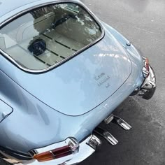 an old blue car is parked on the street