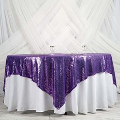 a purple and white sequin table cloth