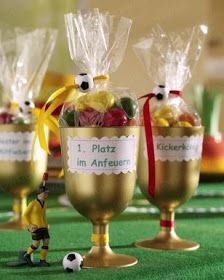 three gold goblets filled with candy and candies on a green tablecloth