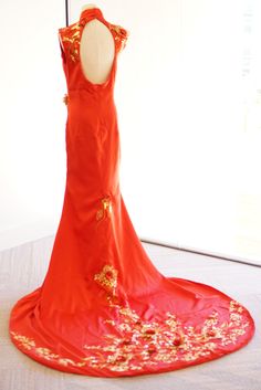 a red dress on display in front of a white wall