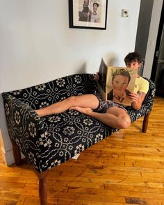 a person laying on a couch reading a book