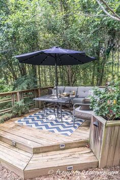 a deck with an umbrella over it in the woods