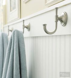 towels hanging on hooks in a white bathroom