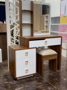 a wooden desk with two drawers and a mirror on it's side, next to a stool