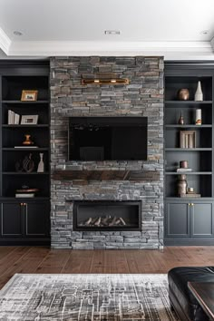 a living room with a stone fireplace and built - in bookshelves