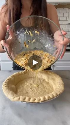 a woman pouring batter on top of a pie crust in a glass pie plate,